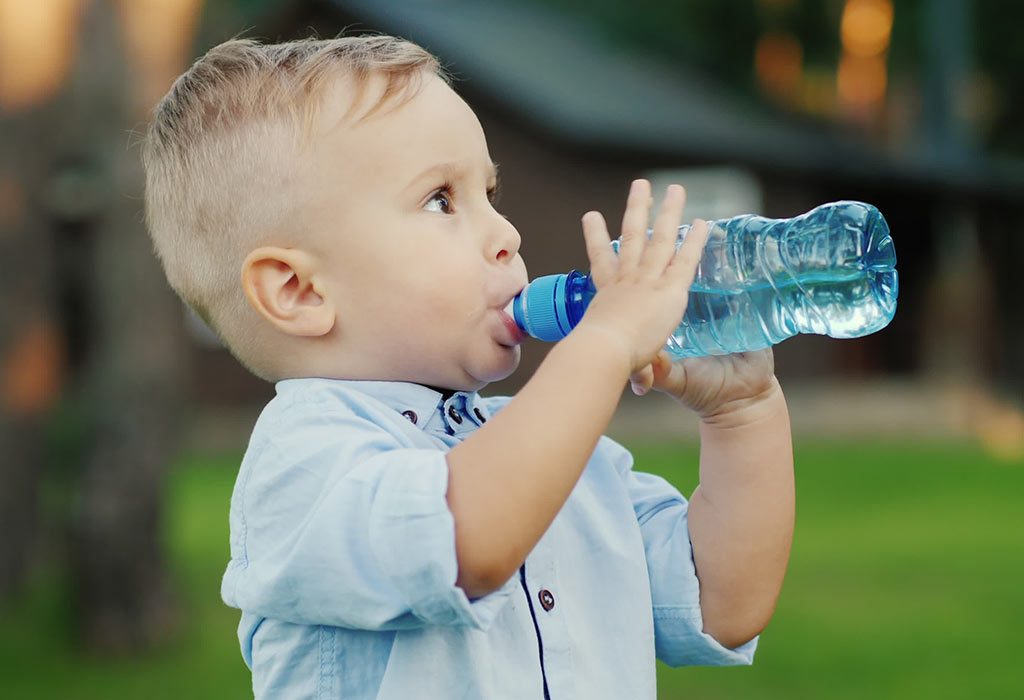 A toddler drinking water through a bottle