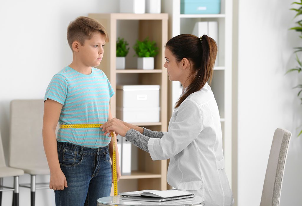 A doctor taking a boy's measurements