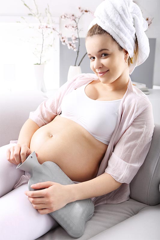 Pregnant woman with hot water bag