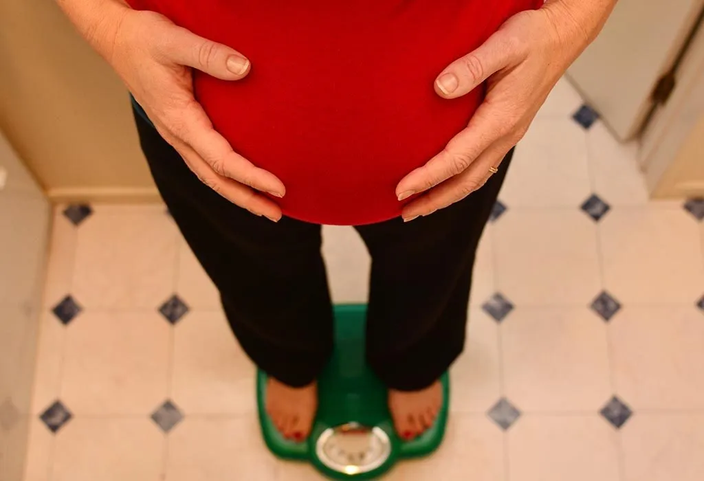 A pregnant woman on a weighing scale