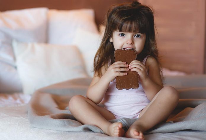 A little girl eating a chocolate