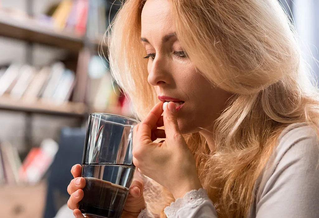 Woman taking vitamin K pill