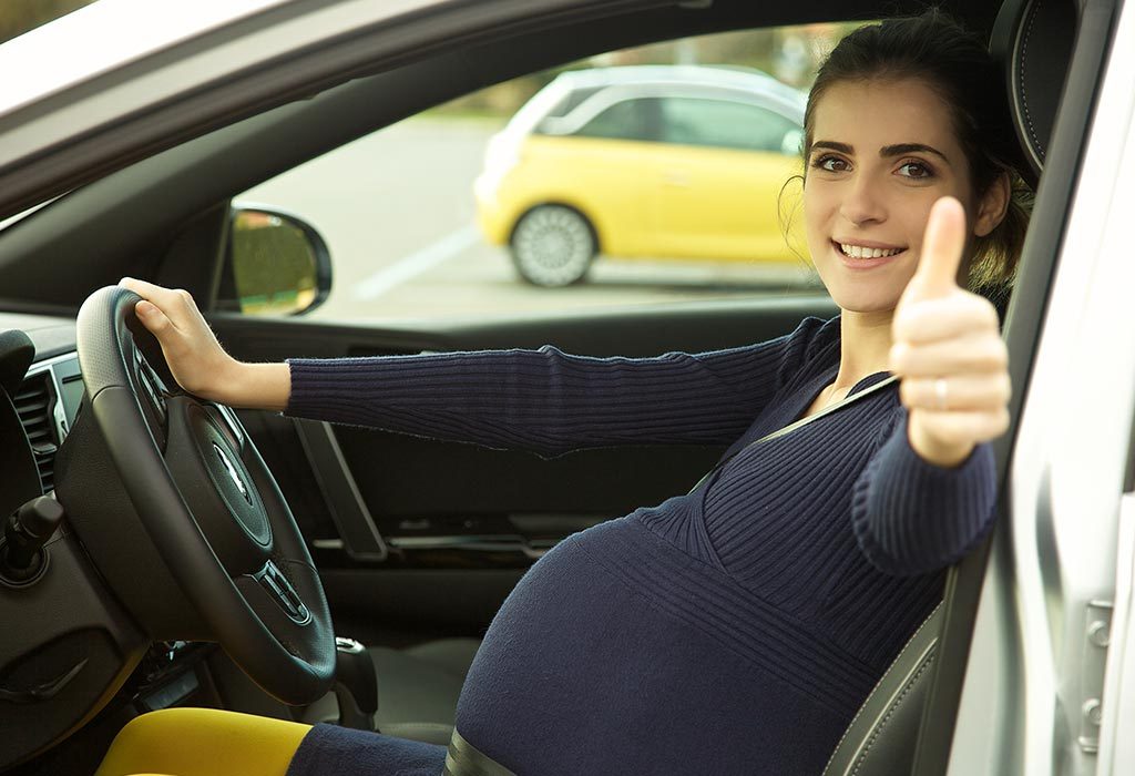 A pregnant woman driving a car