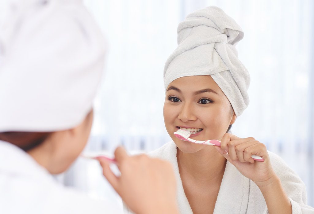 A young woman brushing her teeth carefully