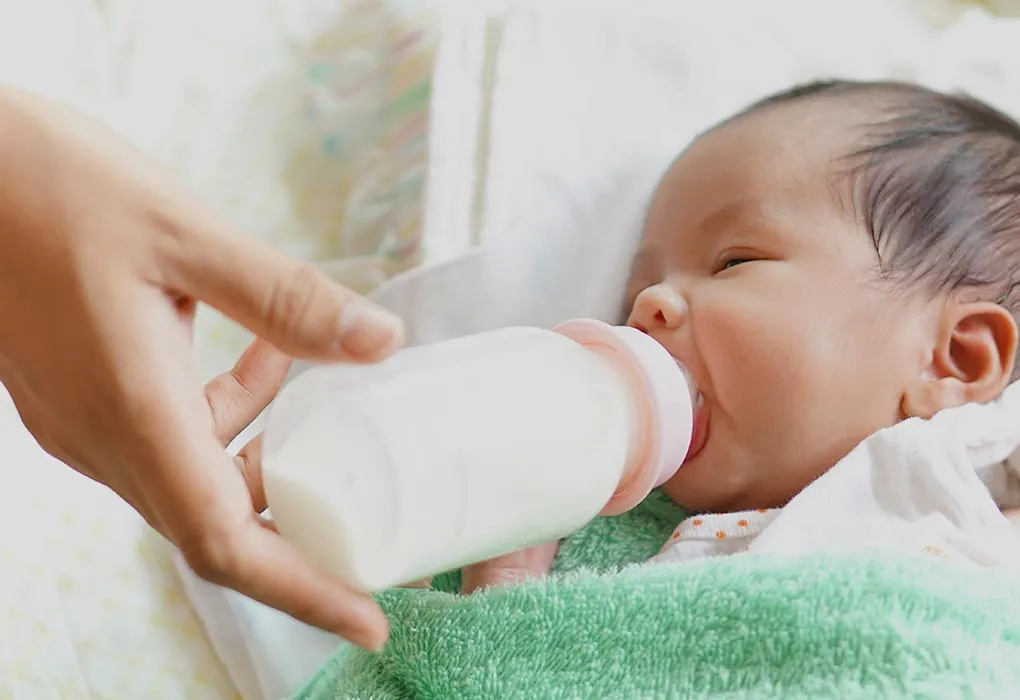 baby drinking milk through bottle