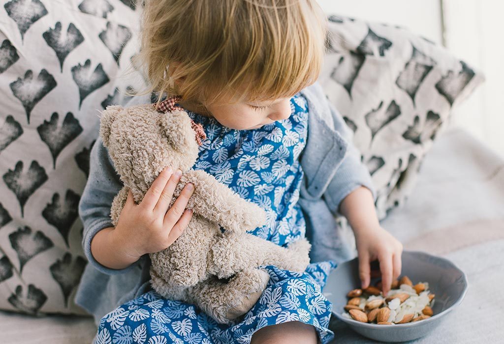 Little girl eating almonds