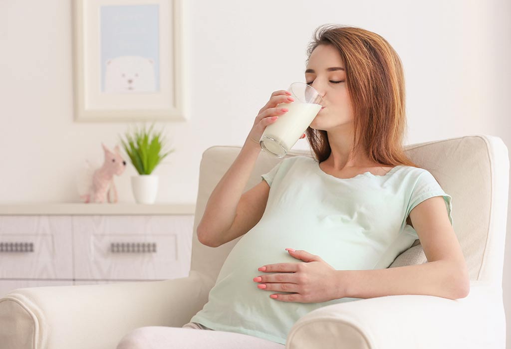 Una mujer embarazada bebe leche