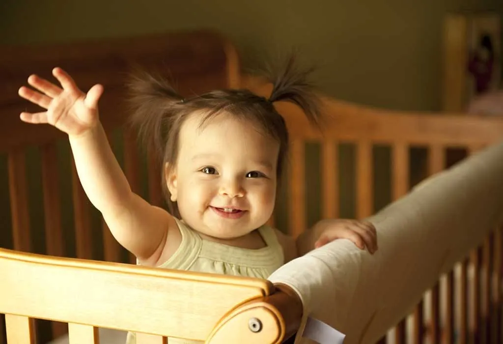 A happy baby in her crib