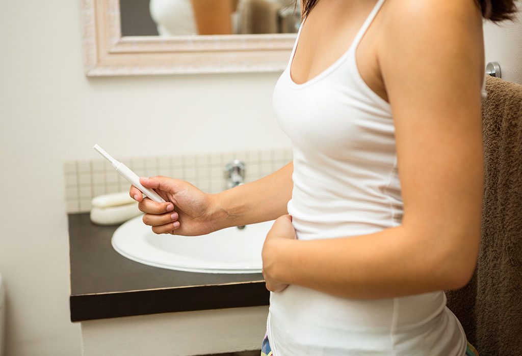 Woman performing pregnancy test in the bathroom