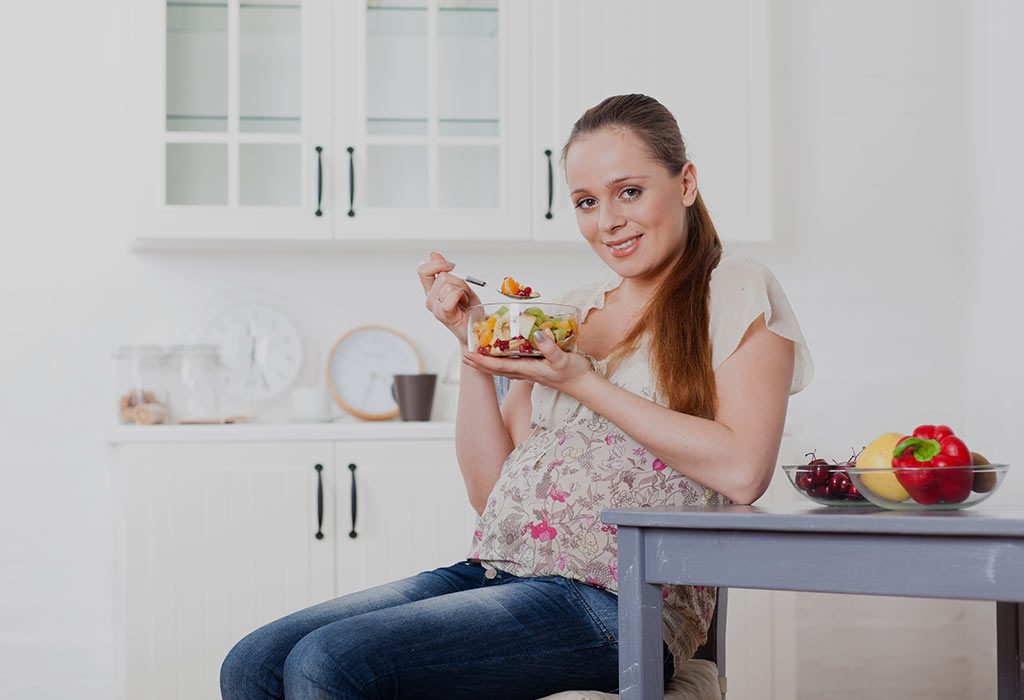 A pregnant woman eating healthy fruits