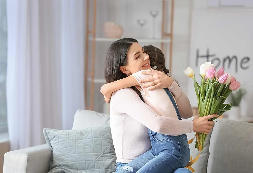 Daughter giving Flower bouquet to mother on mothers day