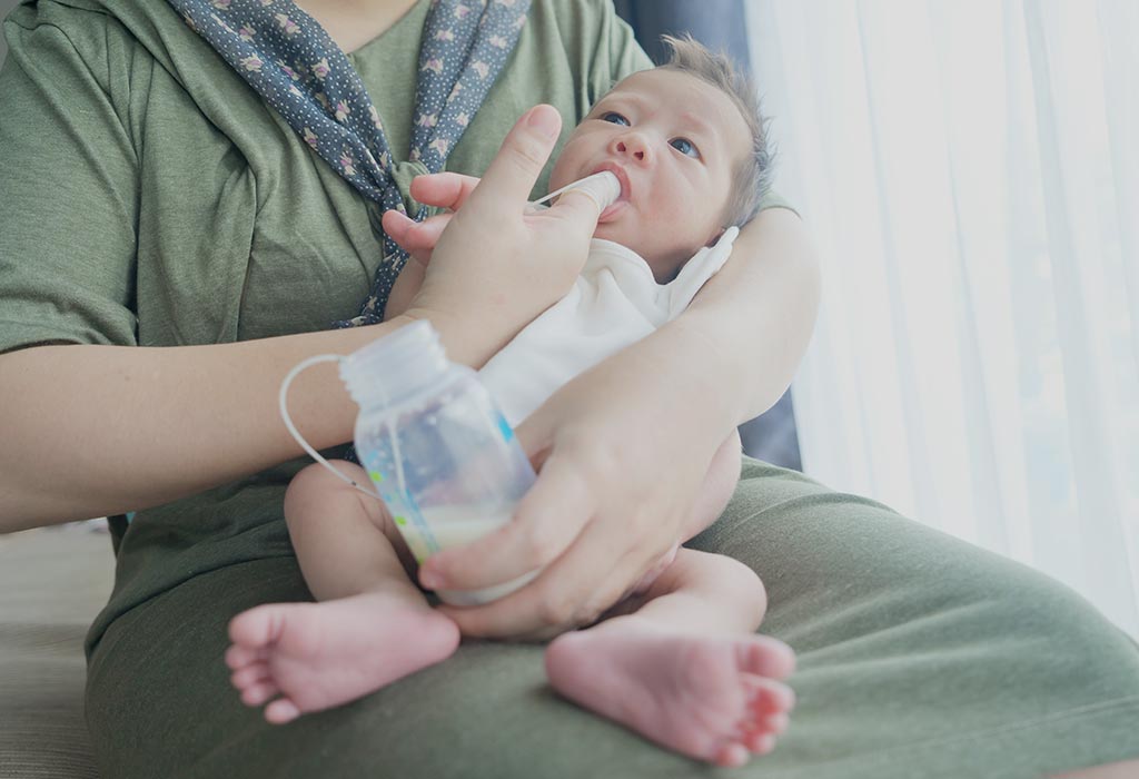 Mama hrănește bebelușul cu degetul