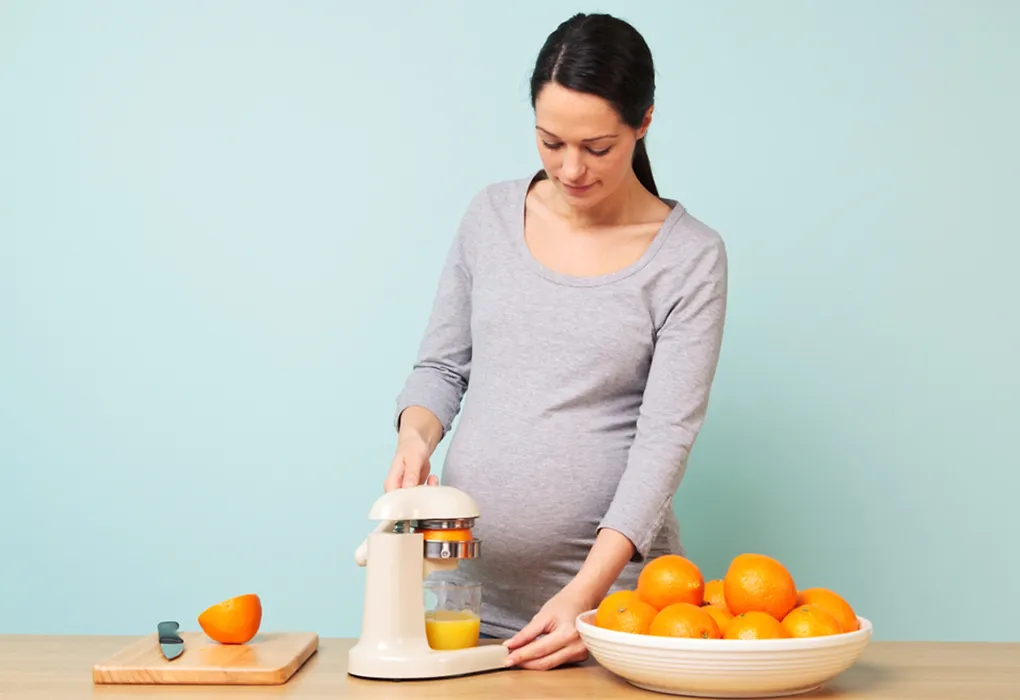 Pregnant woman making orange juice