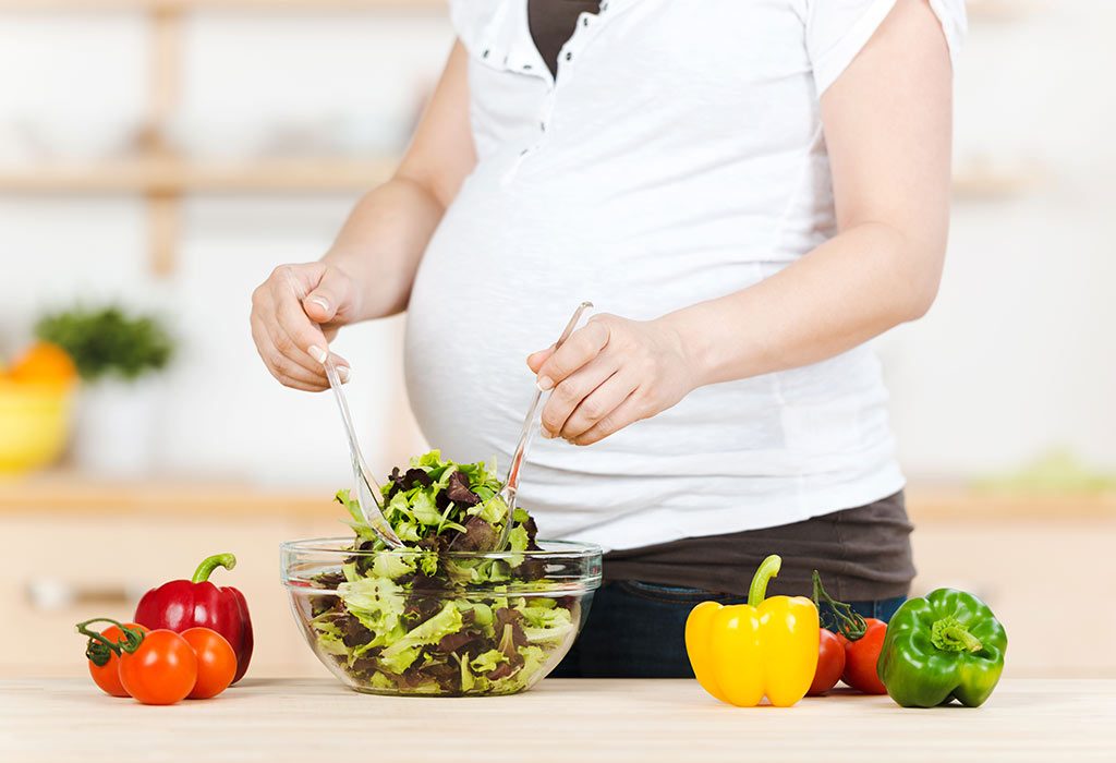 A pregnant woman making salad