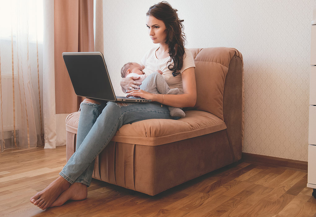 A woman breastfeeding while working