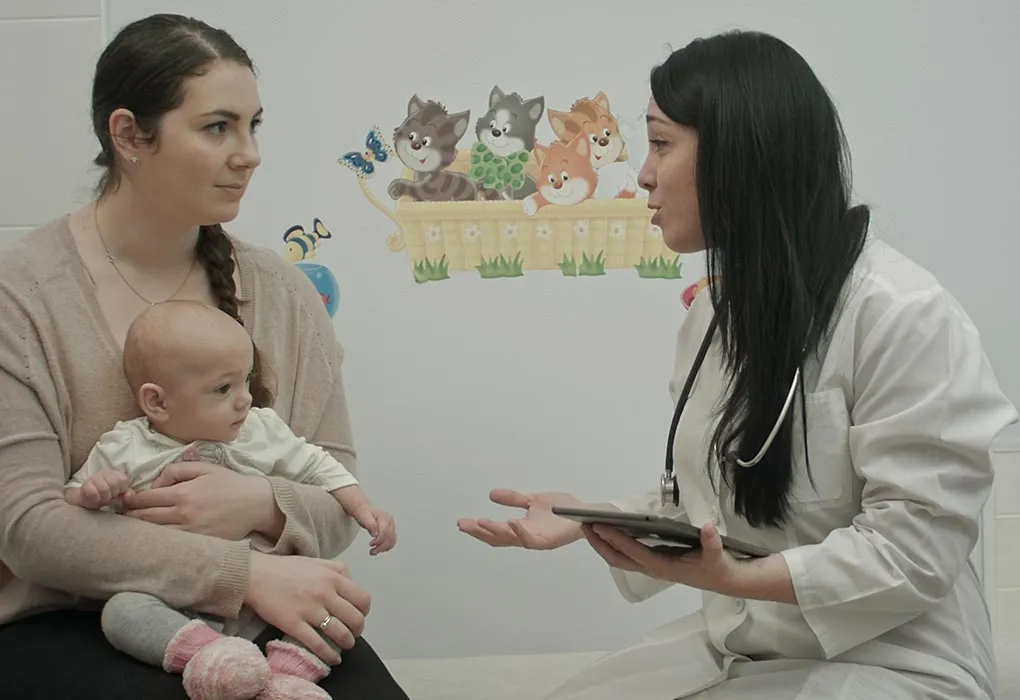 A woman with her baby talking to a doctor