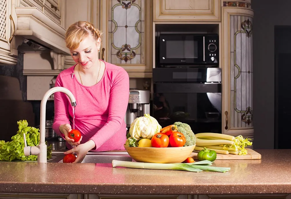 A Pregnant woman washing utensils