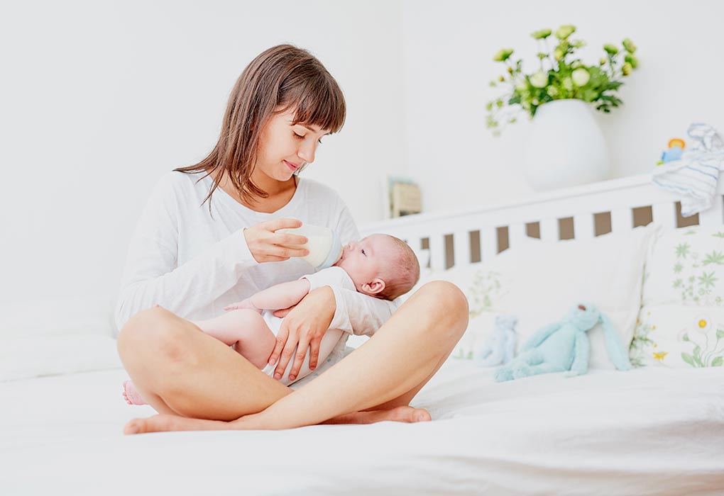 Az anya cumisüveggel eteti a babáját