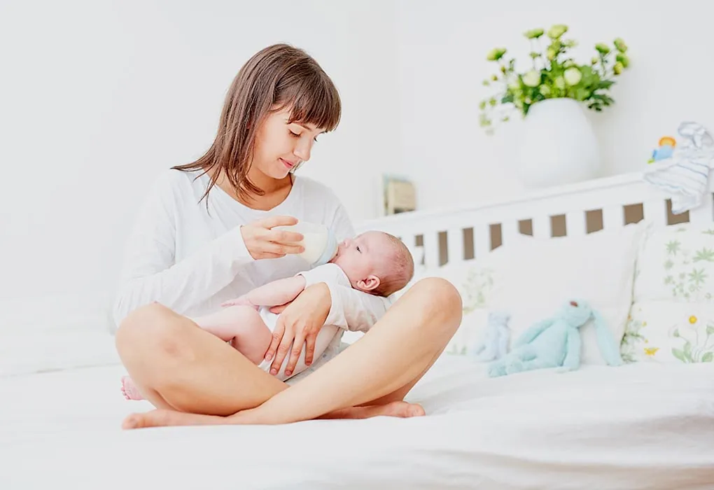 A mother feeds her baby with a bottle