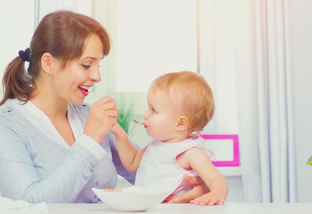 Une mère donne des aliments solides à son bébé