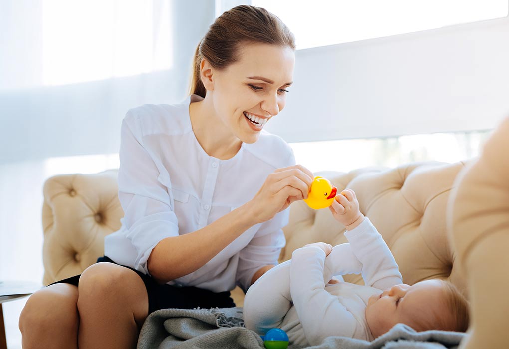 Een moeder geeft haar baby een speeltje