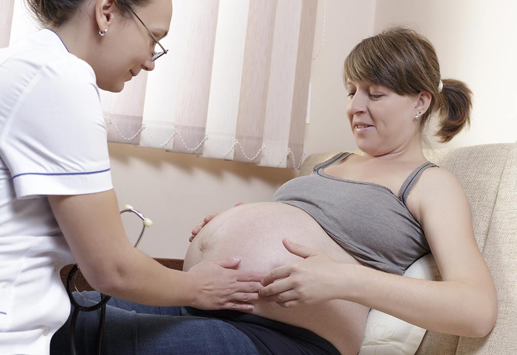 Doctor checking woman's baby bump