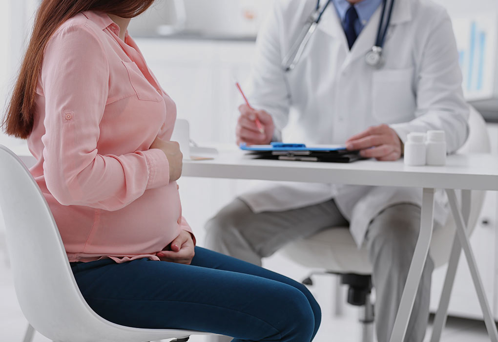 Un medico che parla con una donna incinta