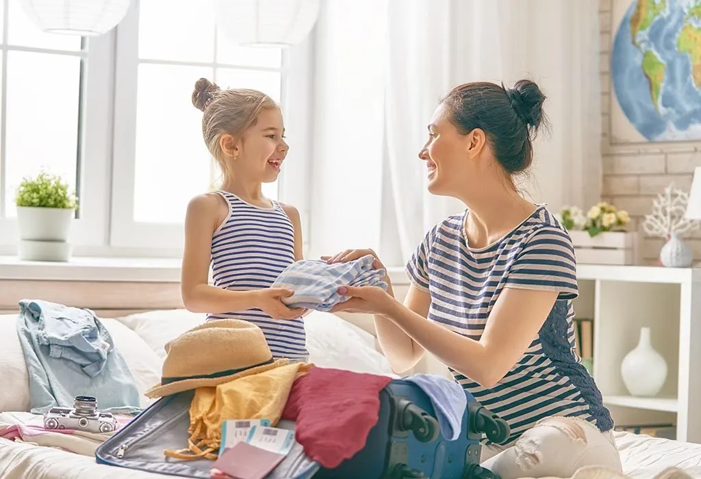 Single mom and daughter packing a suitcase for vacation