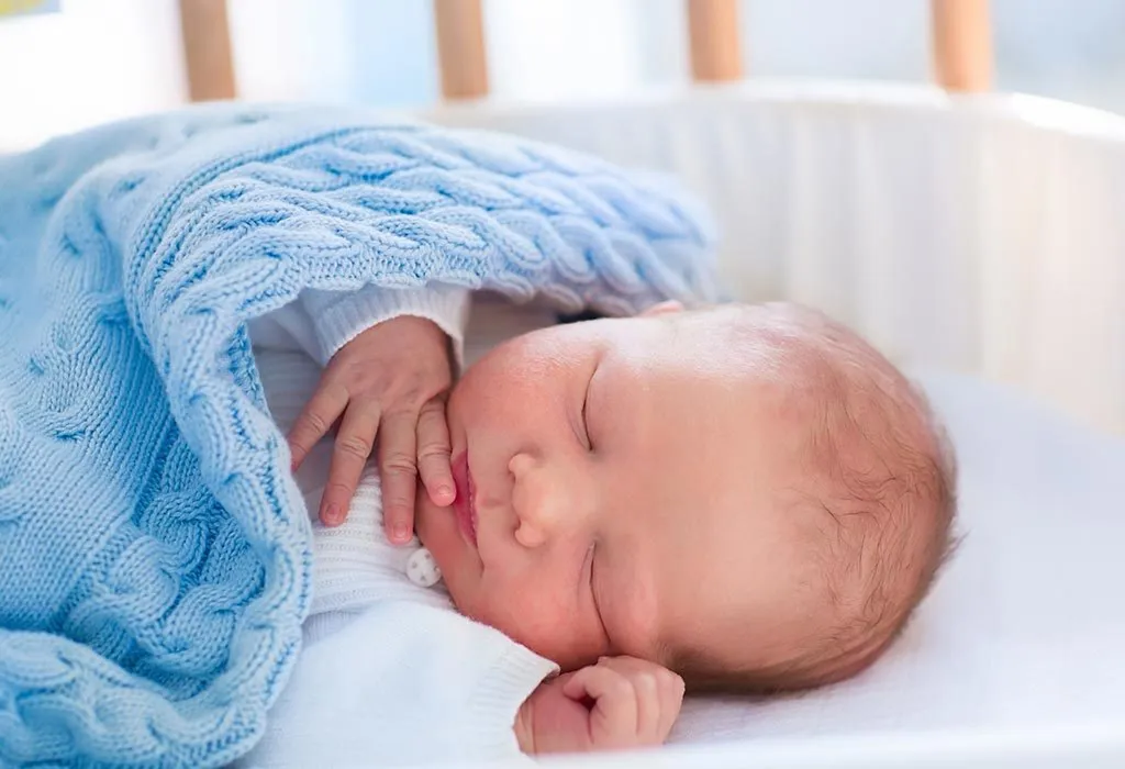 Baby sleeping with a light blanket on him