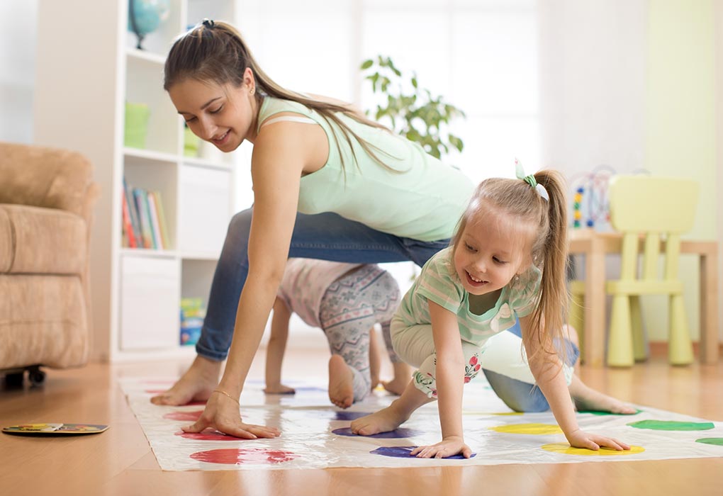 Kids playing twister game with their mother