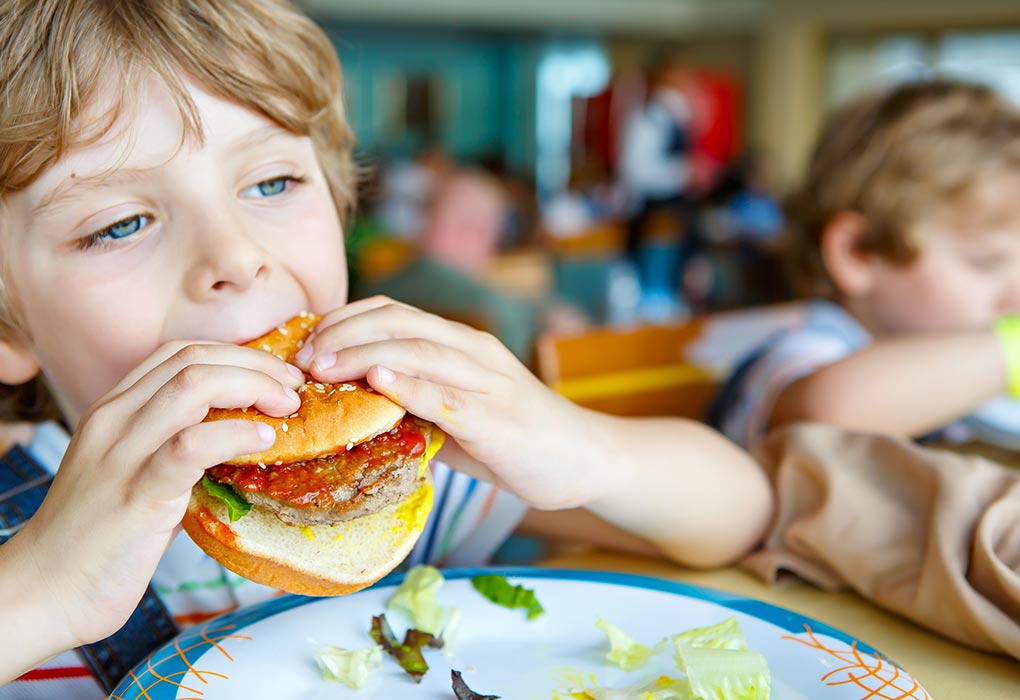 um rapaz a comer alimentos pouco saudáveis