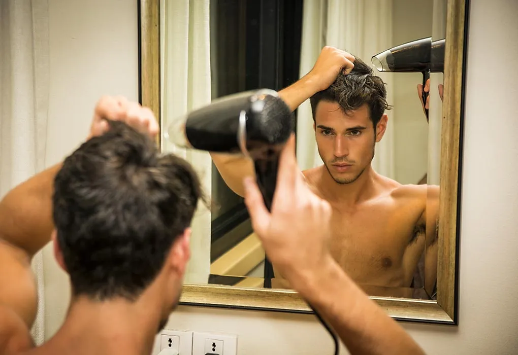 Attractive man drying his hair