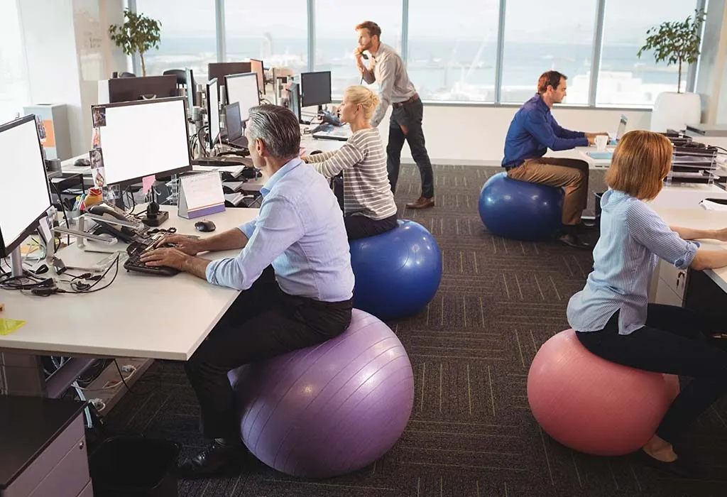 People in office sitting on a fitness ball