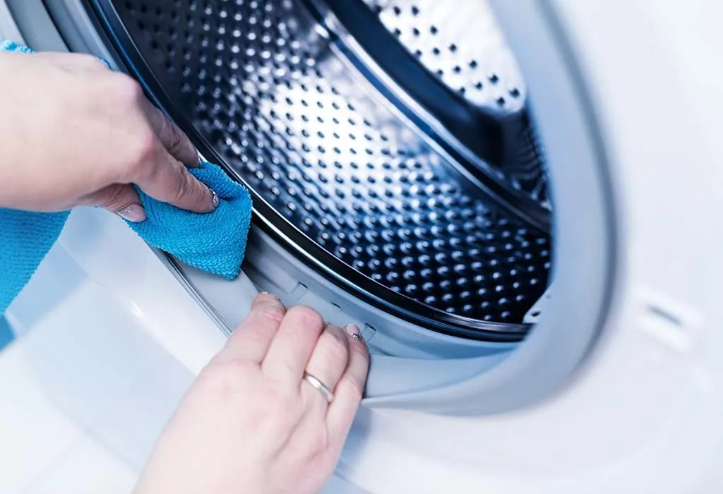 A woman cleaning a front load washing machine