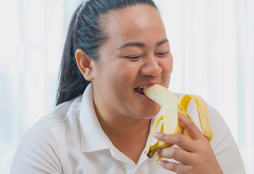 Woman Eating a Banana at Night