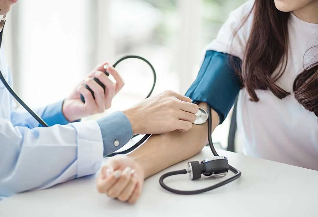 A doctor checking the blood pressure of a woman