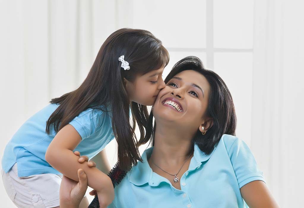 Baby girl kissing her mother's cheek