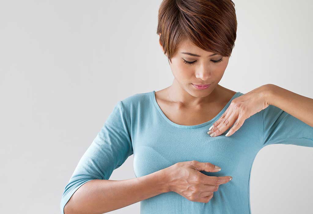 A woman examining her breasts