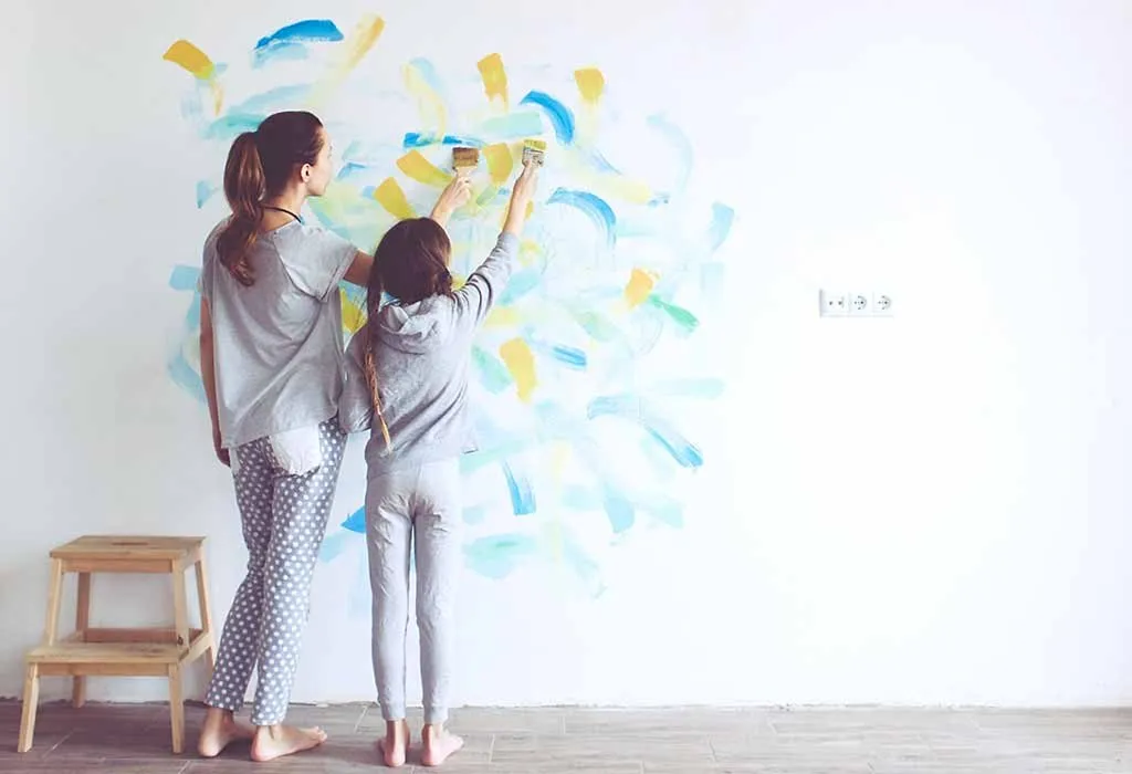 Mother and daughter painting a wall of the house