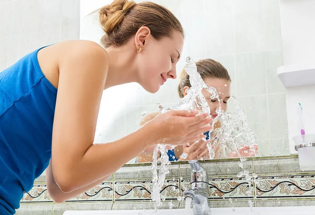 Woman washing her face with plain water