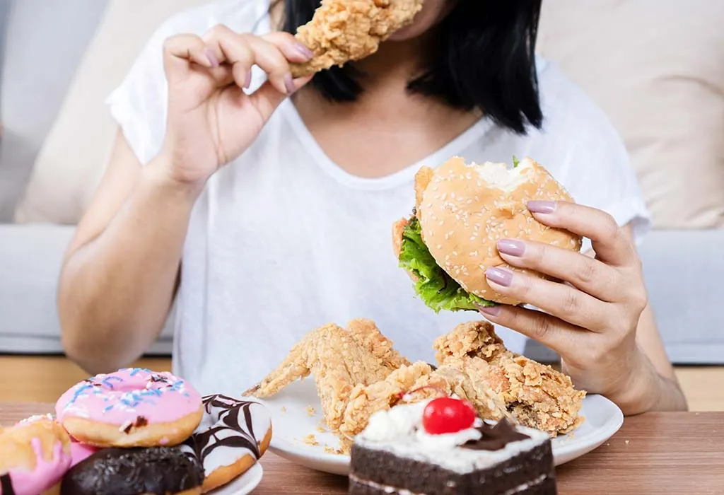 Lady eating burger and fried chicken
