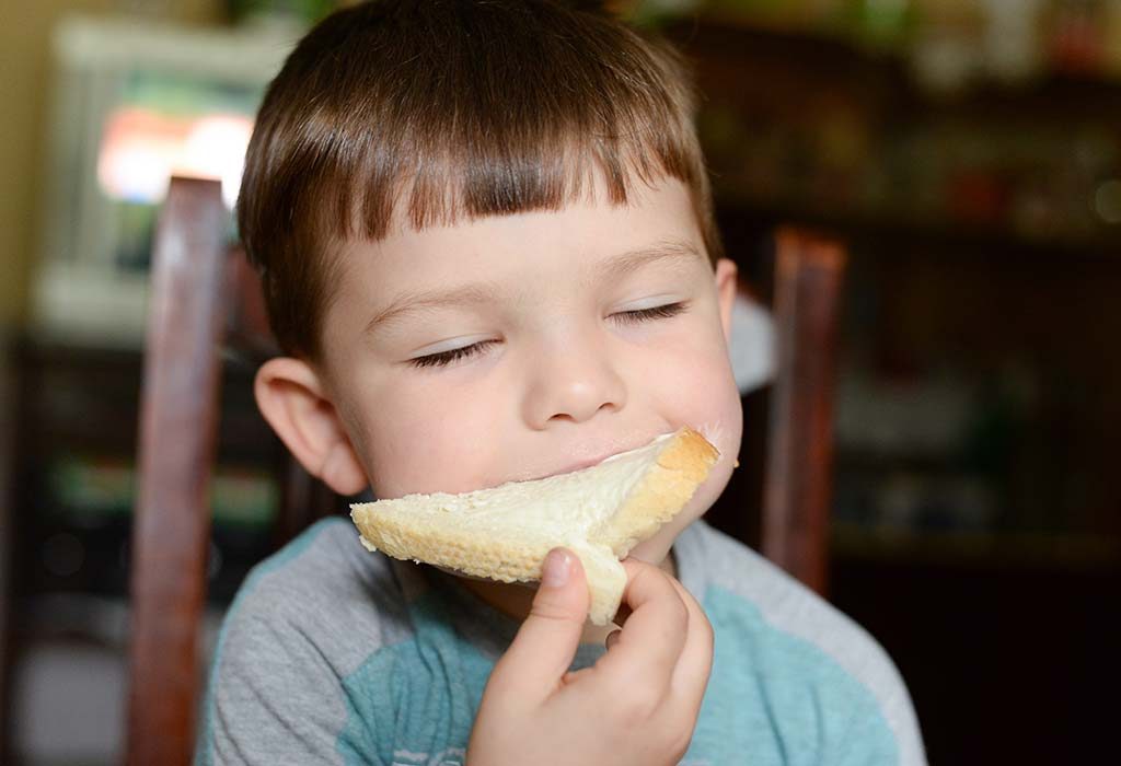Child eating toast with butter