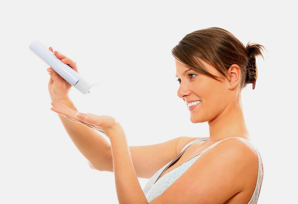 A woman using baby lotion on her body