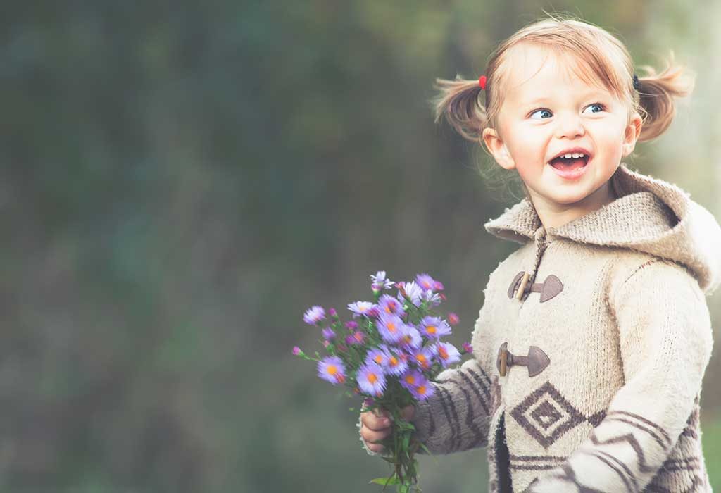 Внешний ребенок. Девочка в свитере держит цветочек. 1 June children's Day foto. 1 June Happy children's Day foto.