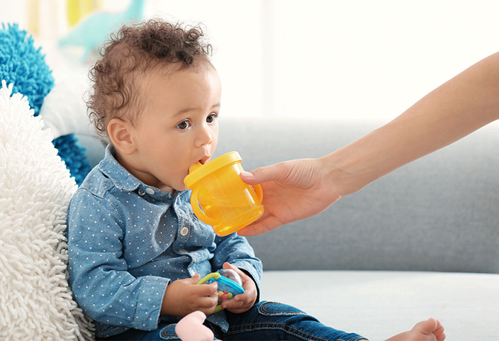 Een baby die vloeistoffen drinkt