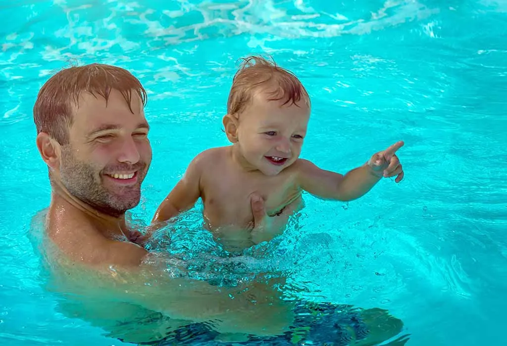 baby swimming with father