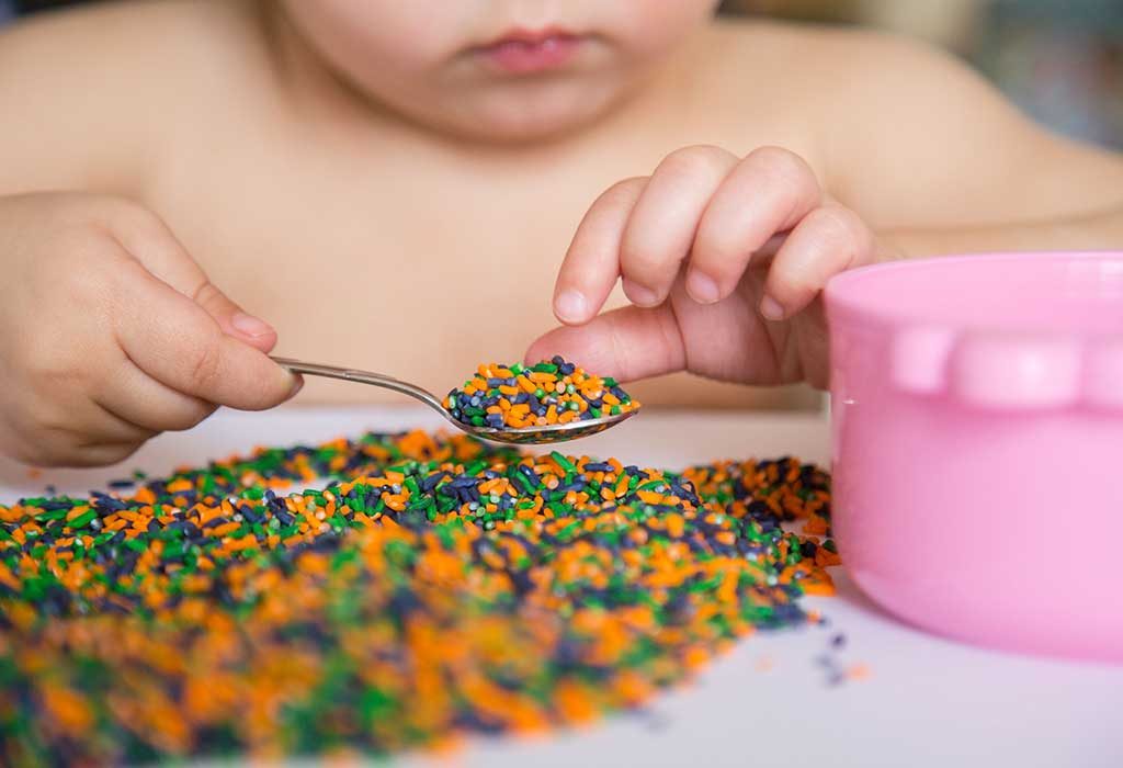 child playing with coloured rice