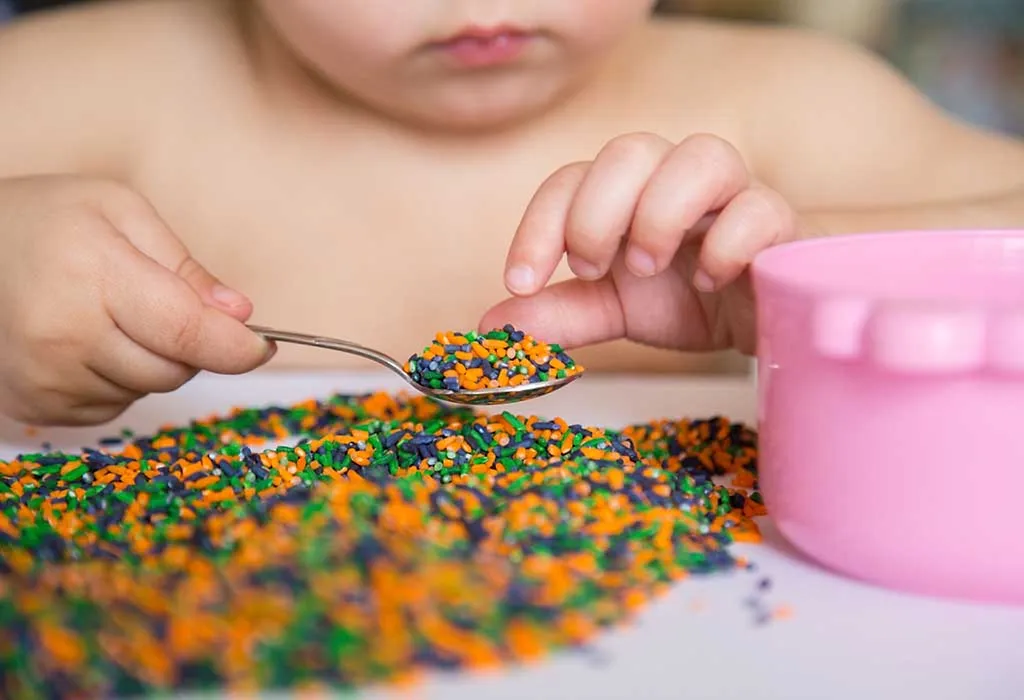 child playing with coloured rice