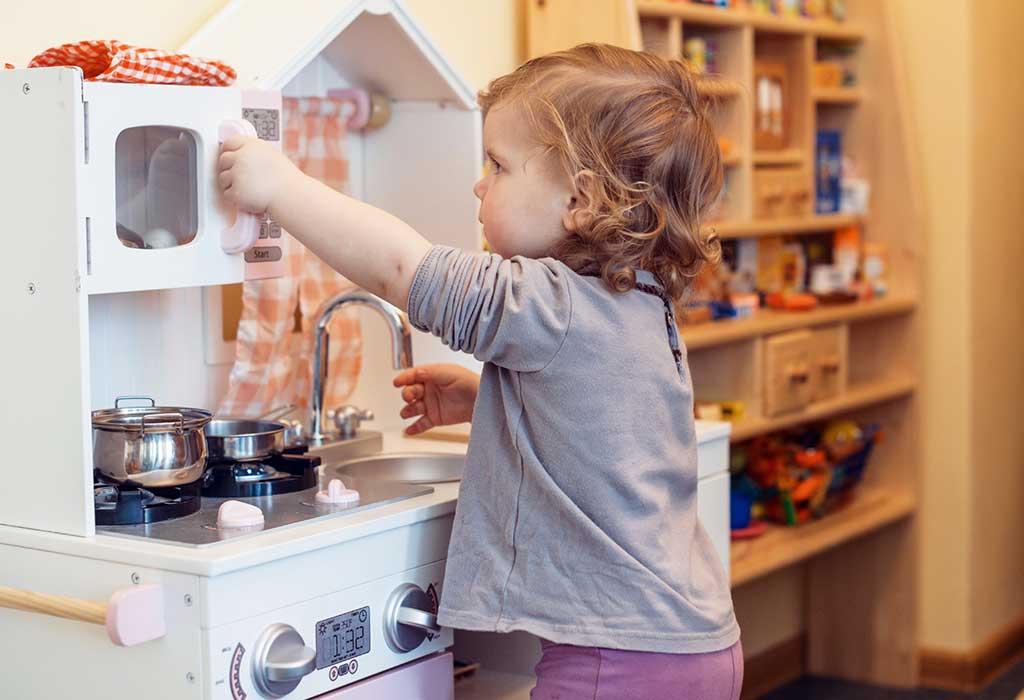 child playing with a toy kitchen