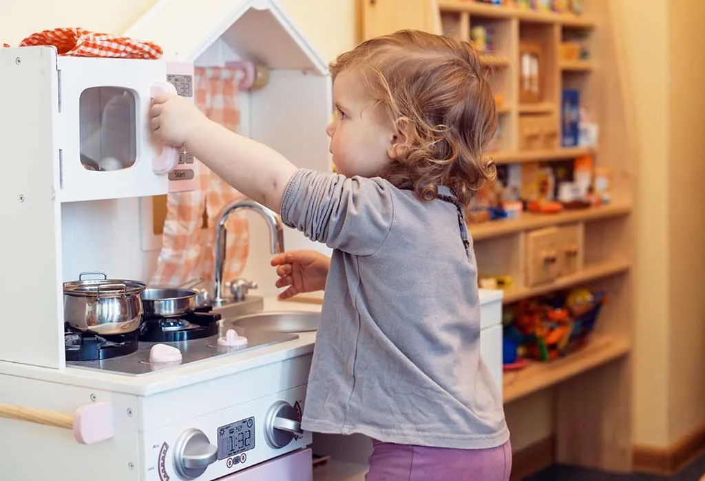 child playing with a toy kitchen